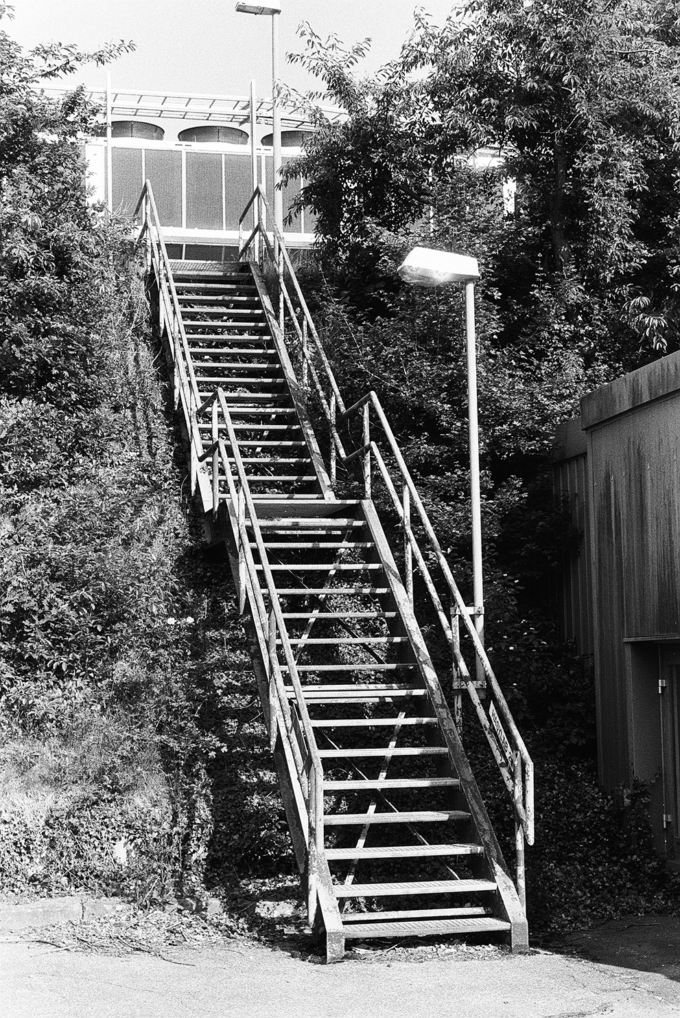 A stair case leading up the hill to large climatization units. Shot Fomapan 400 action.
