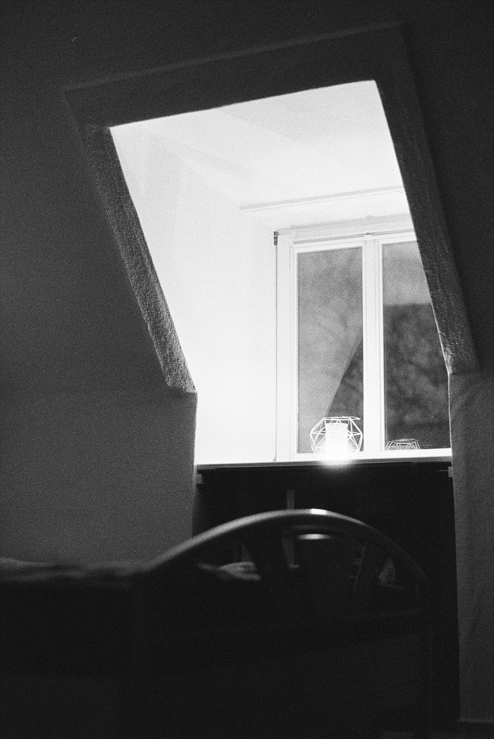 A single candle on a window sill. Shot on Ilford Delta 3200