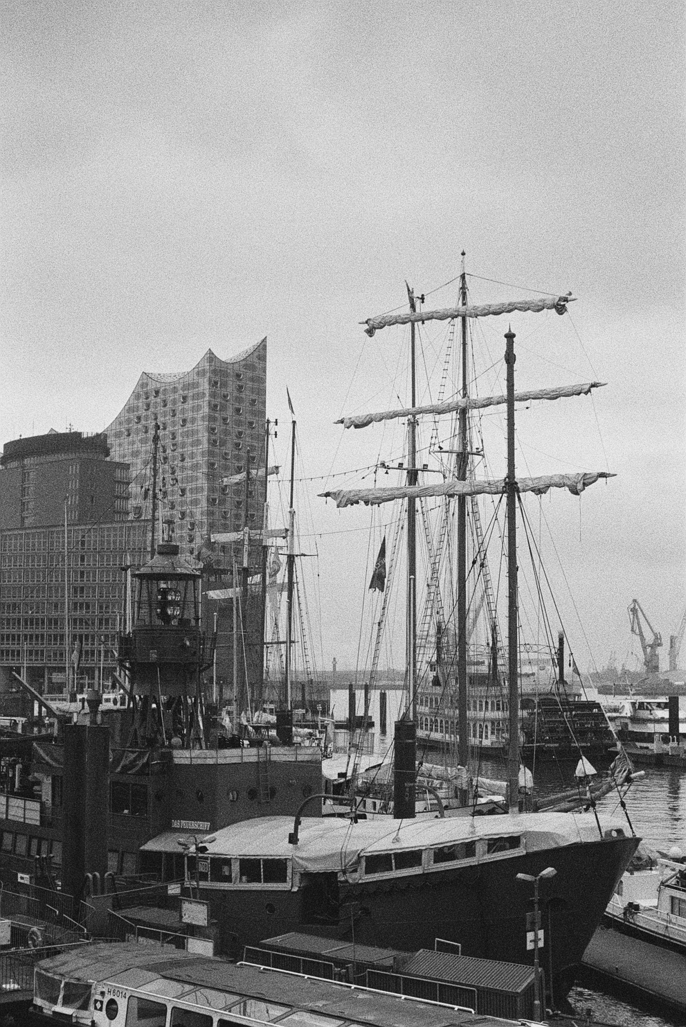 Historic sailing ships with the Elbphilharmonie in the background. Shot on Ilford Delta 3200