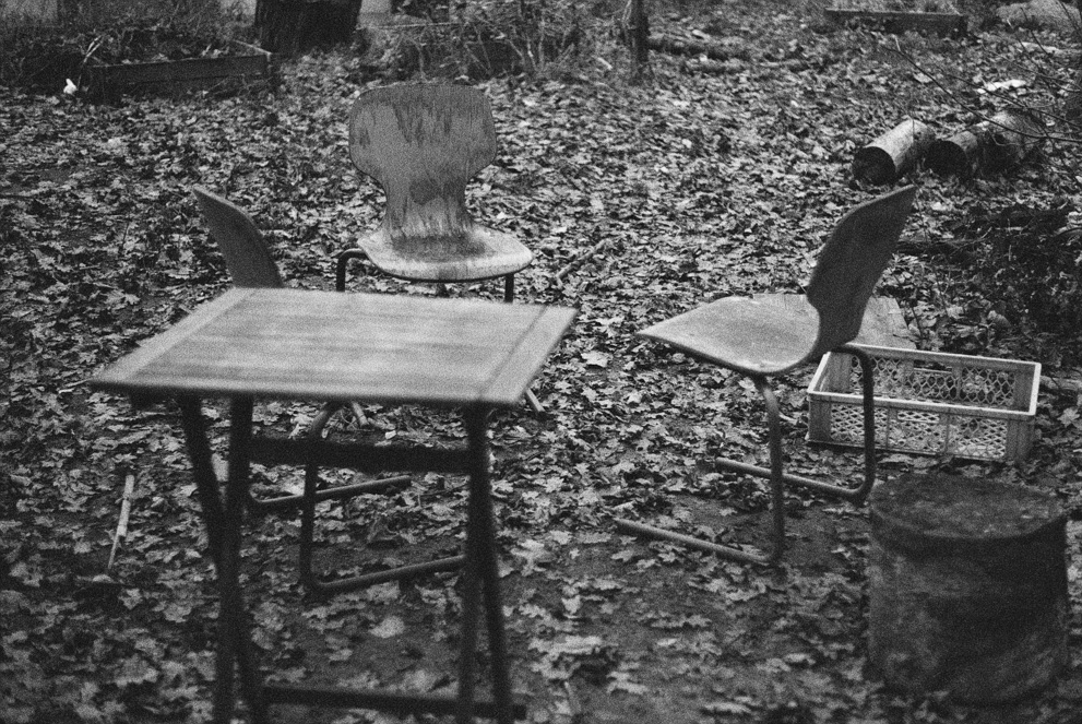 Three chairs and a table outside. Shot on Ilford Delta 3200